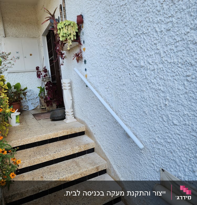 מעקה לבן ליד מדרגות חיצוניות עם עציצים